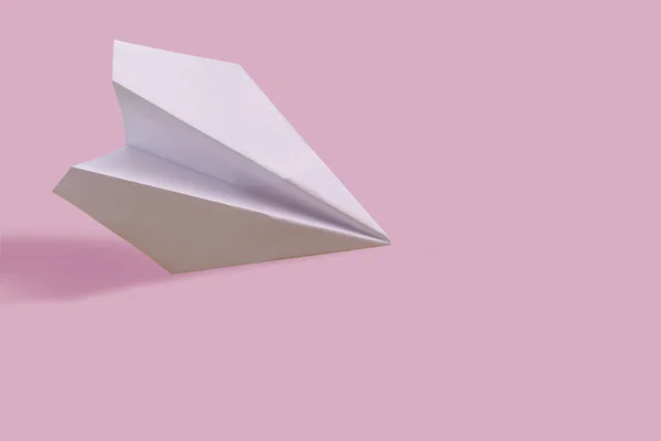 Λευκό χάρτινο αεροπλάνο με φόντο το χρώμα, το ταξίδι και την έννοια των διακοπών. — Φωτογραφία Αρχείου