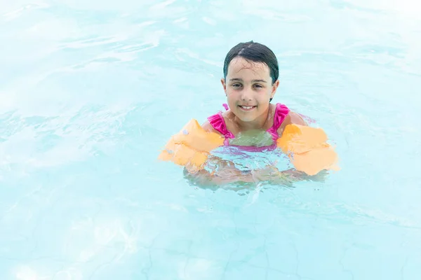 Pequena menina divertida está na piscina — Fotografia de Stock