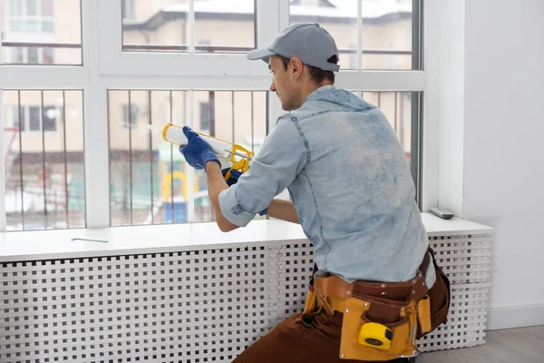 Pracovník instalující a kontrolující okno v domě — Stock fotografie