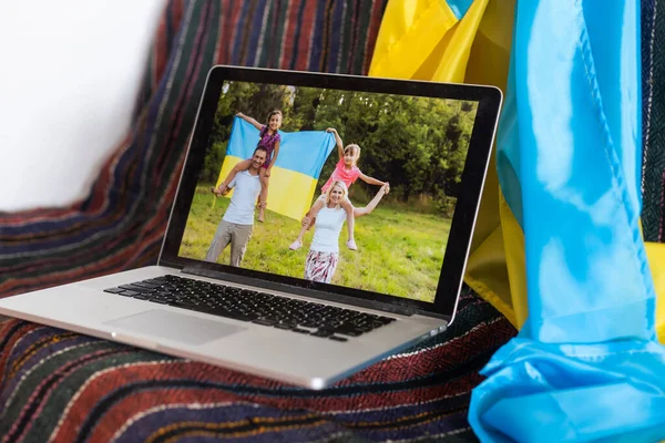 Ноутбук с видеоконференцией возле флага Украины — стоковое фото