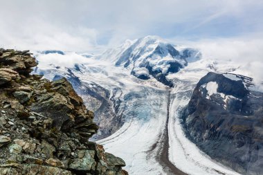 İsviçre Alpleri 'nin tepesindeki dağ katmanlarından oluşan bir manzara.