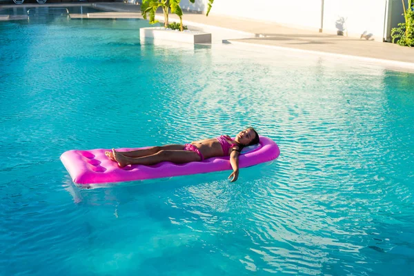 La ragazza si rilassa su un materasso gonfiabile in piscina, facendo bagni d'aria. — Foto Stock