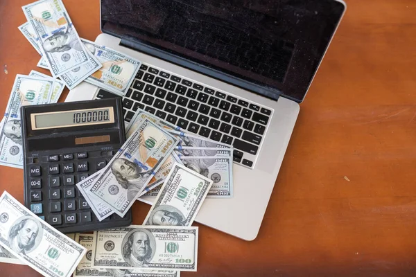 Conceito financeiro e empresarial. laptop, calculadora e dólares em dinheiro. — Fotografia de Stock