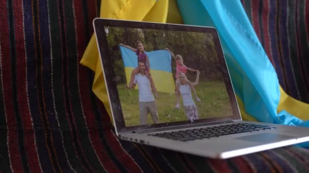 Portátil con videoconferencia y presentación cerca de la bandera de Ucrania. — Vídeo de stock