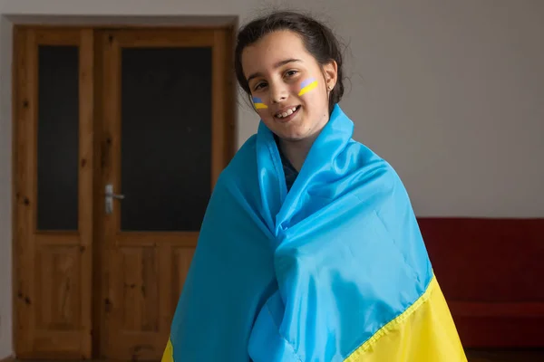 Blick aus nächster Nähe. Porträt eines kleinen Mädchens mit ukrainischer Flagge im Gesicht — Stockfoto