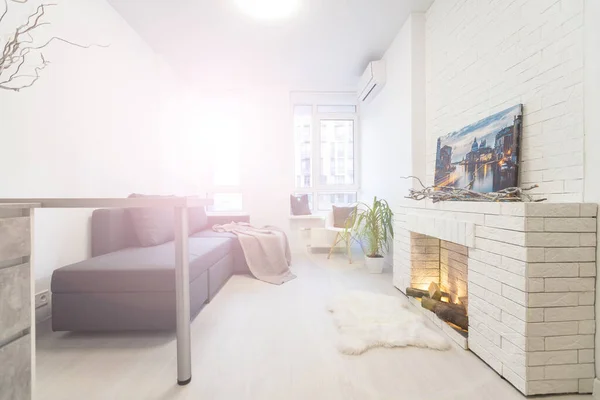 Modische moderne Design-Studio-Wohnung mit einem freien Layout in einem minimalistischen Stil. sehr helles, riesiges Zimmer mit weißen Wänden und Holzelementen. Sitzecke mit Kamin — Stockfoto