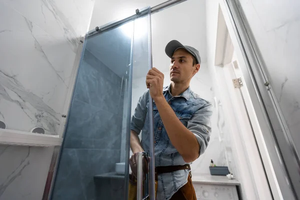 Arbeiter montieren Glastür der Duschabtrennung. — Stockfoto