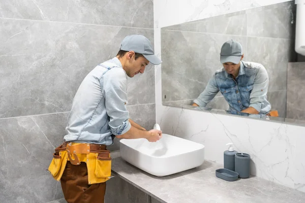 En man är inställningen tvättställ över skåpet i badrummet — Stockfoto