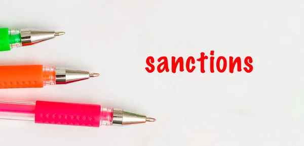 La palabra sanciones está escrita en el cuaderno. Concepto político y económico — Foto de Stock