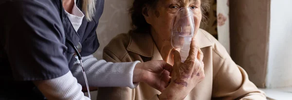 Jovem Médica Segurando Máscara de Oxigênio Sobre a Cara de Pacientes Seniores — Fotografia de Stock