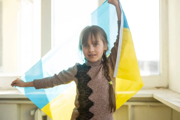 Kleines Mädchen mit ukrainischer Flagge auf weißem Hintergrund — Stockfoto