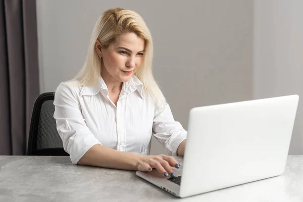 Aufnahme einer attraktiven Geschäftsfrau, die an ihrem Arbeitsplatz am Laptop arbeitet. — Stockfoto