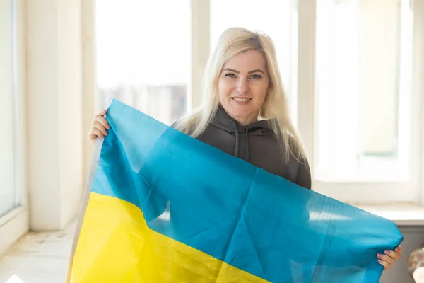 Mulher refugiada com bandeira de ucraniano. Patriotismo, luta, esperança. Guerra na Ucrânia. Liberdade para a Ucrânia. Não há guerra.. — Fotografia de Stock