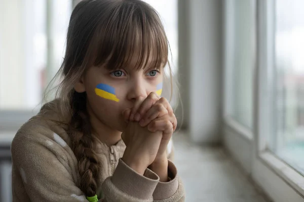 Menina com fita bandeira ucraniana orando. Símbolo de paz e rezar pela Ucrânia. — Fotografia de Stock