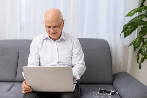 Felice vecchio uomo d'affari caucasico sorridente che lavora online guardando webinar podcast sul computer portatile e l'apprendimento conferenza corso di formazione chiamata prendere appunti sedersi, concetto di elearning — Foto Stock