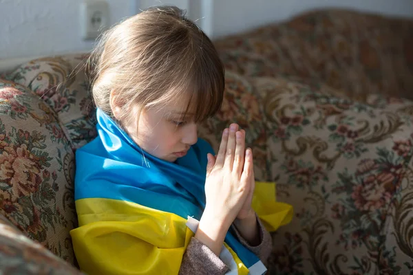 Be för Ukraina. Barn med ukrainsk flagga. Liten flicka viftar med nationell flagga och ber för fred. — Stockfoto