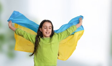 Çocuk Ukrayna 'nın mavi ve sarı bayrağını bembeyaz üzerinde taşıyor. Ukrayna 'nın Bağımsızlık Günü. Bayrak Günü. Anayasa günü. Geleneksel Ukrayna bayrağıyla nakışçı kız