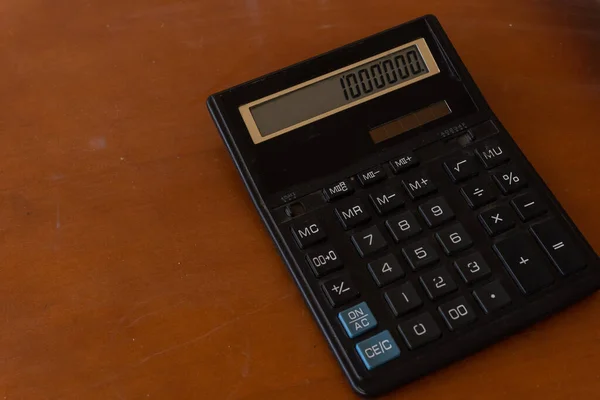 A velha calculadora na mesa de madeira — Fotografia de Stock