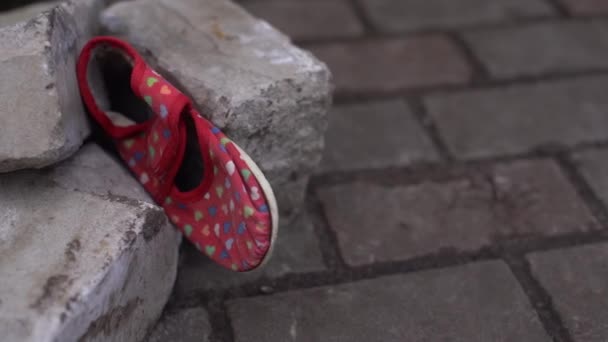 Kids shoes on representing civilian casualties in an active war zone — Stock Video