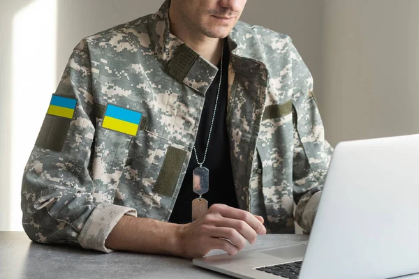 Ουκρανός πολεμιστής άνδρας ντυμένος με στρατιωτική pixel ομοιόμορφη το κίτρινο-μπλε σημαία της Ουκρανίας — Φωτογραφία Αρχείου