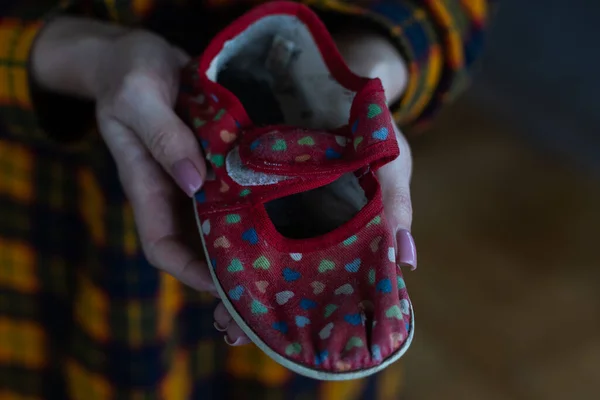 Kobieta trzyma dziecięcy but. Wojna na Ukrainie. — Zdjęcie stockowe