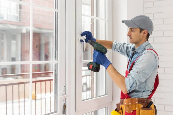 Stilig ung man installera Bay fönster i ett nytt hus byggarbetsplats. — Stockfoto