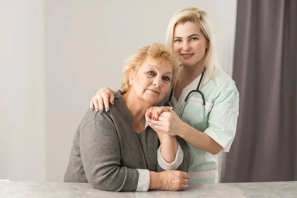 Επισκέπτης υγείας και ηλικιωμένη γυναίκα κατά την επίσκεψη στο σπίτι. — Φωτογραφία Αρχείου