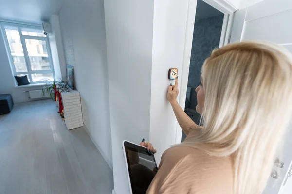 Mujer usando el sistema de control del hogar de pared inteligente — Foto de Stock