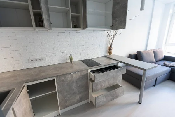 Interior of the small living equipped kitchen in studio apartments in minimalistic style with light color — Stock Photo, Image