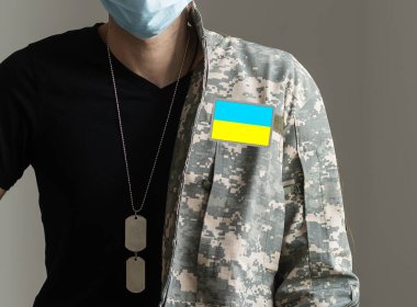 Ukrainian man warrior dressed in a military pixel uniform the yellow-blue flag of Ukraine clipart
