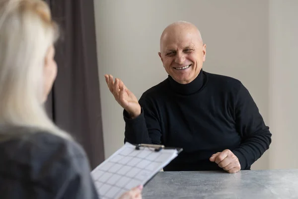 Terapi seansında yaşlı adamla röportaj yapan kadın psikiyatristin portresi. — Stok fotoğraf