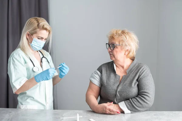 Медсестра крупным планом делает прививки пожилой женщине. — стоковое фото