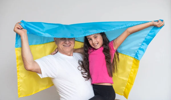 Літній чоловік і дівчинка з прапором України. — стокове фото