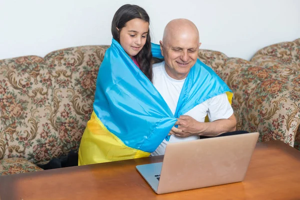 Nagyapa és unokája laptop és zászló Ukrajna — Stock Fotó