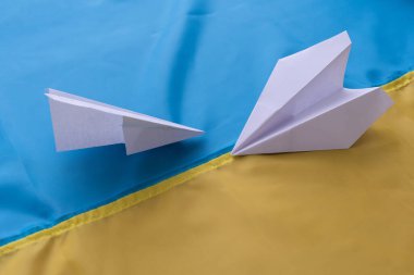Ukrayna bayrağı taşıyan iki kağıt uçak. El yapımı sanat konsepti