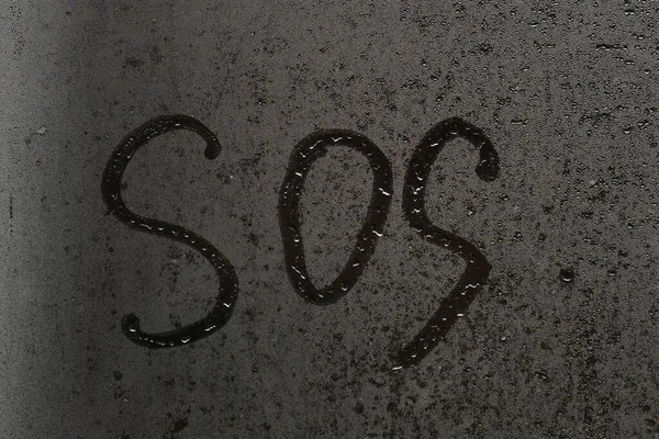 안개낀 창문에 붙어 있는 SOS 라는 비문 — 스톡 사진