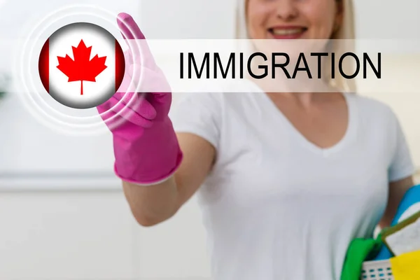拿着加拿大国旗和文字移民的妇女 — 图库照片