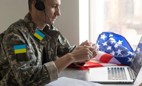 Guerrero ucraniano vestido con un uniforme militar pixel la bandera amarillo-azul de Ucrania — Foto de Stock