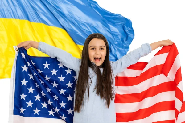 Приваблива дівчинка, яка тримає американський прапор на фоні українського прапора. — стокове фото