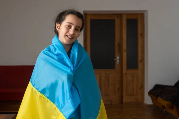 Menina coberta com bandeira da Ucrânia. Conceito de estar com a nação ucraniana em guerra com a Rússia. — Fotografia de Stock