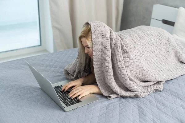 Nudná žena odpočívající a ležící na gauči si dává pauzu, dívá se na film, pracuje doma na laptopu v obýváku. Líný víkend. — Stock fotografie