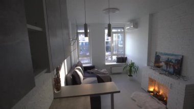 Dairedeki modern tavan arası stüdyo dairesinin içinde. Oda, mobilya, şöminenin yanındaki kanepe.