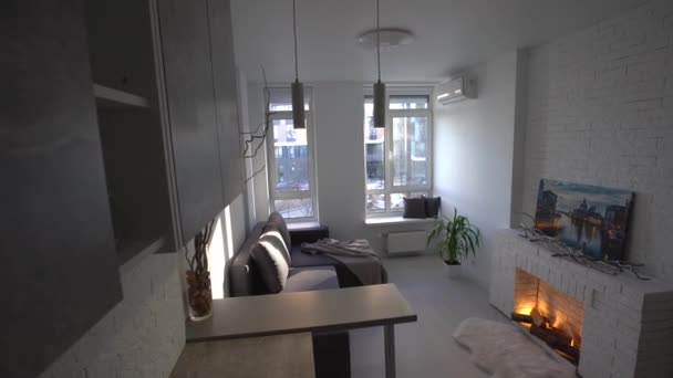 Interior del moderno loft cocina-estudio en el apartamento. Habitación, muebles, sofá cerca de la chimenea de madera — Vídeos de Stock