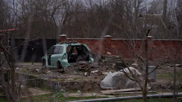 Zrezivělé opuštěné auto na parkovišti, obklopeno plotem a ostnatým drátem. Pár aut stojí v jímce pro automobilovou demontáž nebo zpracování kovů. Restaurování retro vozu. — Stock video