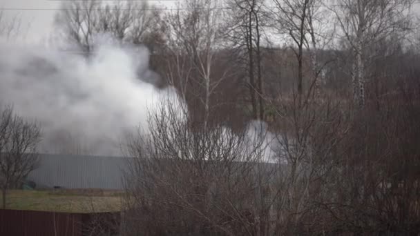 Oheň v soukromém domě hustý kouř stoupá nad střechy. — Stock video