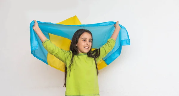 Gyermek hordozza lengő kék és sárga zászló Ukrajna elszigetelt fehér. Ukrán Függetlenség Napja. Zászlónap. Az alkotmány napja. Lány a hagyományos hímzés zászló Ukrajna — Stock Fotó