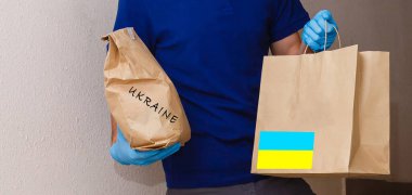 Bir adam içinde Ukrayna 'ya insani yardım olan bir kutu tutuyor.