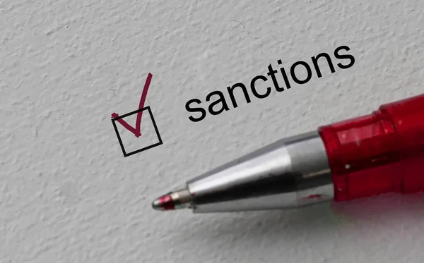Vinkje op het woord sancties en over de streep en rode pen. Closeup, concept — Stockfoto