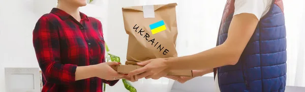 Чоловік тримає коробку допомоги для українських біженців та бідних громадян, які опиняються у війні між Україною та Росією. Концепція гуманітарної допомоги. Пожертвуйте на біженців. — стокове фото