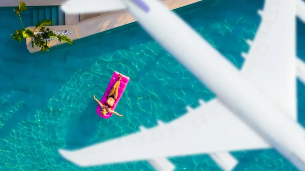 Femme nager sur matrass gonflable dans la piscine et l'avion sur outre concept de voyage — Photo